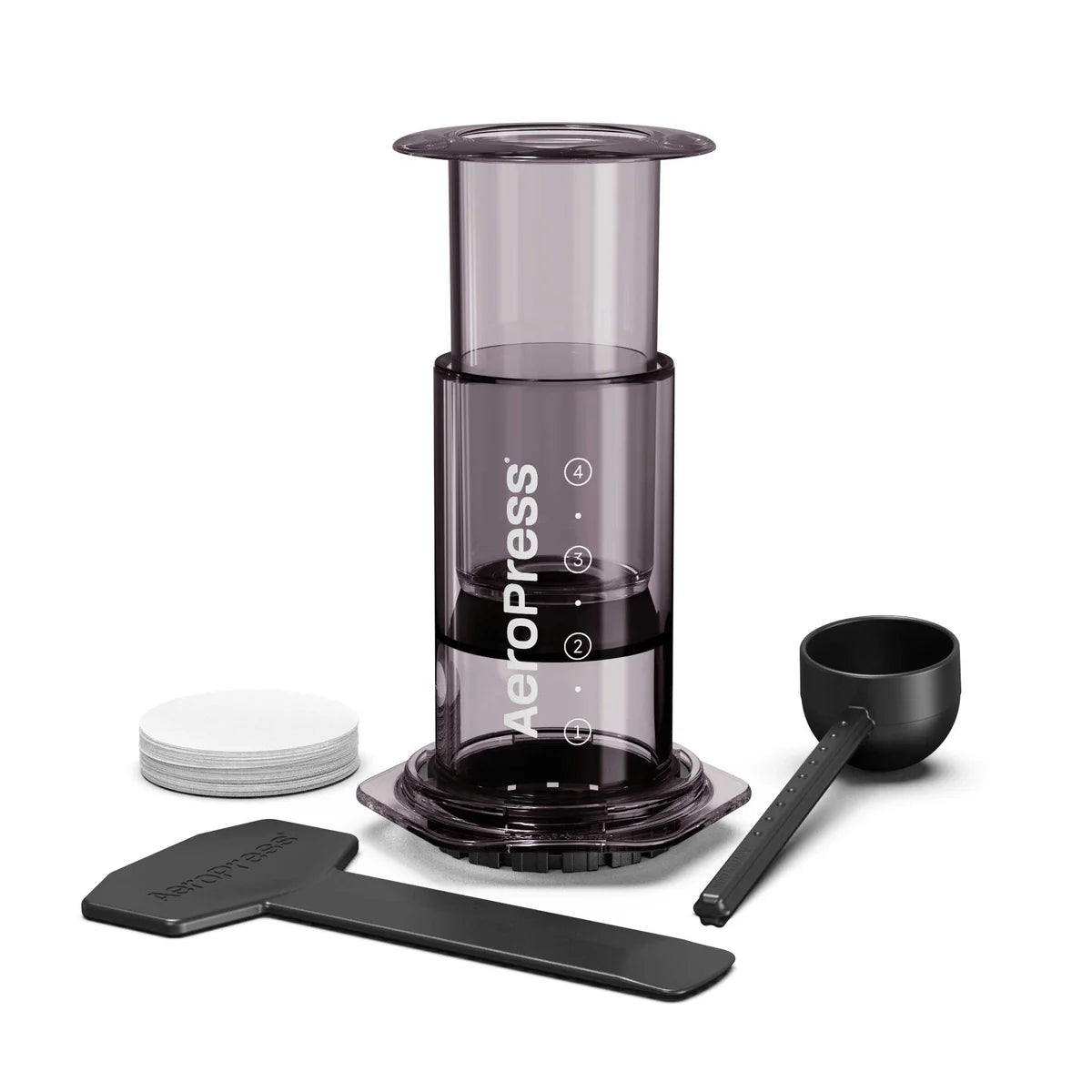 AeroPress coffee brewer with paper filters, scoop, and stirrer